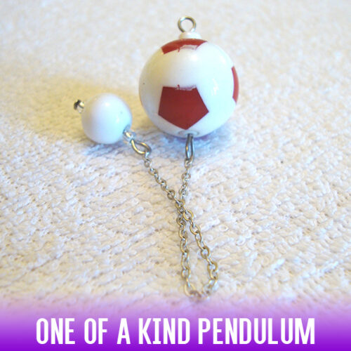 A soccer-ball style red & white acrylic bead dowsing pendulum with an easy-to-use white